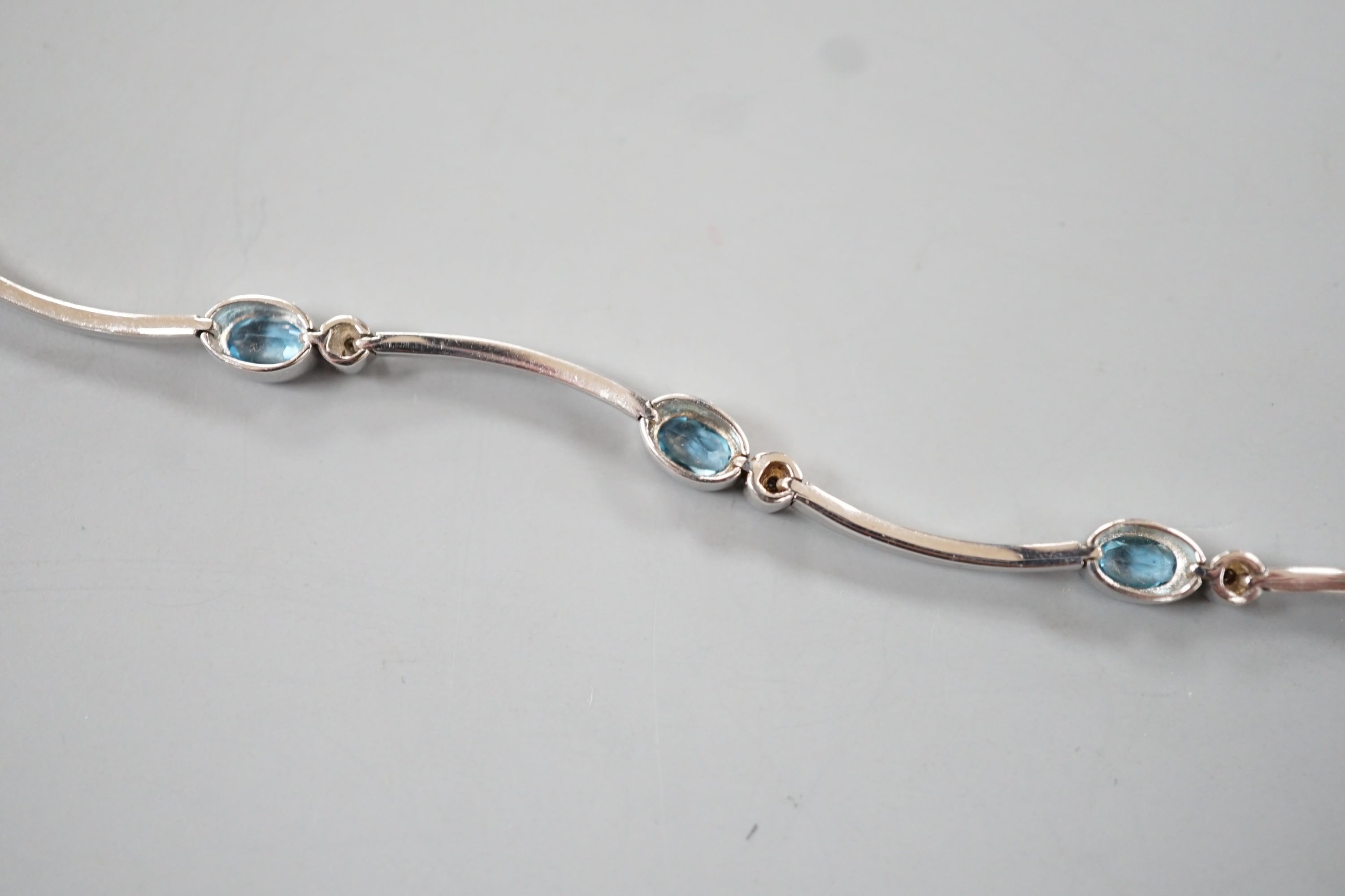 A modern 9ct white gold, blue topaz? and diamond chip set bracelet, 18.5cm, gross 8.8 grams.